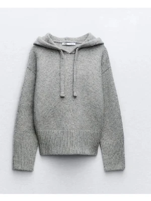 Zara stickad hoodie - Mysig grå stickad hoodie från Zara med huva och dragsko. Tröjan har breda ribbade muddar vid ärmslut och nederkant. Den är lite nopprig ner till.