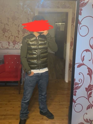Grön Moncler cardigan - Snygg grön pufferjacka från Moncler med dragkedja framtill. Jackan har långa ärmar och en glansig finish som ger en modern look. Perfekt för kyligare dagar när du vill hålla stilen. 🧥
