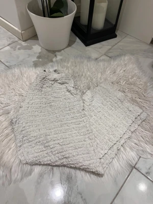 Beiga fluffiga byxor från ZARA - Supermysiga och fluffiga loungewear-byxor från ZARA i beige färg. Byxorna har en krinklad textur och resår i midjan för extra komfort. Perfekta för chill hemma eller när du vill vara extra bekväm. Passar korta tjejer 