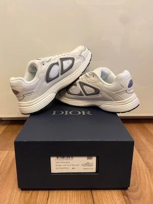 Vita Dior B30 - Säljer ett par Dior B30 i vit/beige, storlek 44. Perfekta om du vill vara välklädd utan att ens försöka för mycket.  • Storlek 44 • Mycket fint skick • Original med box & dustbag • Sjukt clean färg som passar allt  Skorna som får folk att kolla ner två gånger 👀  📦 Skickas inom 1 dag 💰 Pris: 2299 