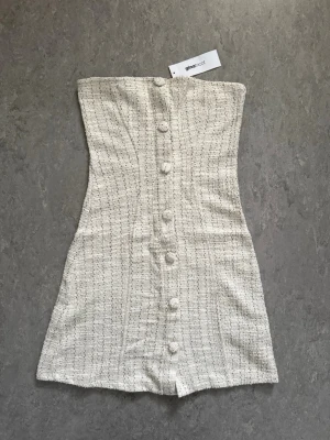 Ginatricot klänning - Beige tube-top klänning från ginatricot i färgen S, köpt för 399kr. Säljer klänningen då den inte kommer till användning. 