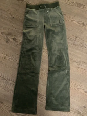 Olivgröna Juicy Couture byxor - Säljer ett par olivgröna mjukisbyxor från Juicy Couture i mjuk velour. Riktigt skön passform. Använd fåtal gånger ❤️