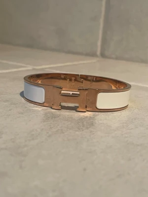 Armband - Snyggt armband med färgerna vit och rosegold. Armbandet har kvinnlig passform och är i mycket bra skick