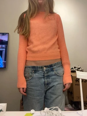 Croppad stickad tröja i korall - Trendig croppad stickad tröja i korallfärg med rund hals och långa ärmar. Storlek XS och sitter ”tajt.” Kommer från sellpy och andvänt en gång🥰
