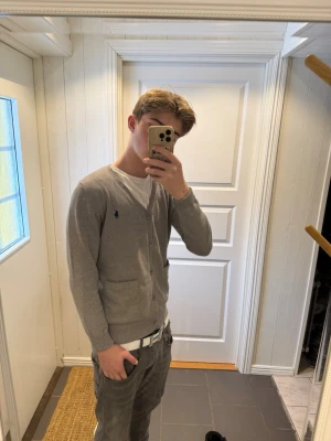 Grå kofta från Ralph Lauren - grå kofta från Ralph Lauren med knäppning framtill och två fickor. Lätt att ha på sig om man vill va snygg eller bara ha en vardaglig look 