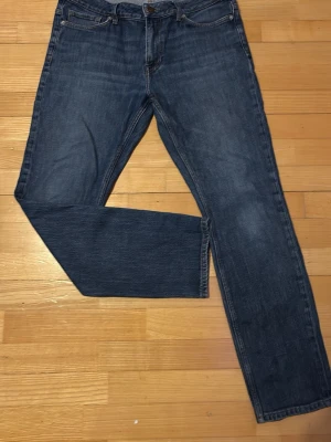 Blå raka jeans från Levi's - Säljer ett par klassiska blå jeans från Levi's med rak passform. Jeansen har fem fickor, knappgylf och är tillverkade i slitstarkt denimtyg. Perfekta för dig som gillar en tidlös och enkel stil. Den är slim #2