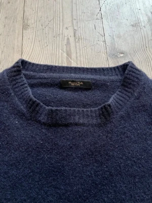 Mörkblå Kashmir tröja från Massimo dutti  - Mörkblå stickad tröja från Massimo Dutti med rund halsringning och ribbade muddar vid ärmslut och nederkant. Tröjan har en klassisk, rak passform och är tillverkad i ett mjukt, värmande material som passar perfekt för kyligare dagar.