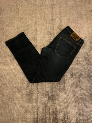Mörkblå Crocker Jeans  - Snygga mörkblå Crocker Jeans. Jeansen har en rak passform och är tillverkade i mjukt denimtyg. Perfekta för dig som gillar en stilren och tidlös look.
