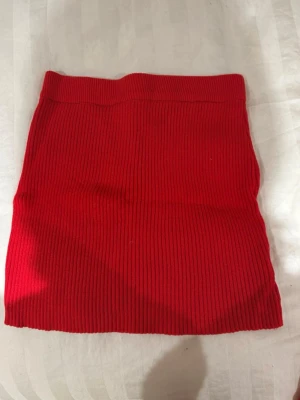 Röd stickad kortkjol - Röd stickad kjol, finns matchande tröja. Använd 1 gång 