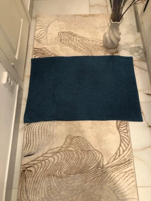 Blå rektangulär badrumsmatta - Säljer en stilren blå rektangulär matta i mjukt tyg. Mattan har en enkel, enfärgad design och passar perfekt i hallen, badrummet eller köket. Materialet känns skönt under fötterna och färgen ger ett modernt intryck.