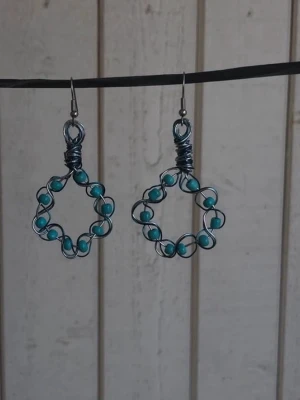Handgjorda örhängen med turkosa pärlor - Unika örhängen i silverfärgad metalltråd formade som blommor och dekorerade med turkosa pärlor. De har en bohemisk och kreativ stil, perfekta för dig som vill sticka ut med ditt smyckesval. Mina handgjorda örhängen.  Blåa pärlor och silverfärgad metall.  Nickelfria!   Följ min Instagram för mer <3 @veras.smycken