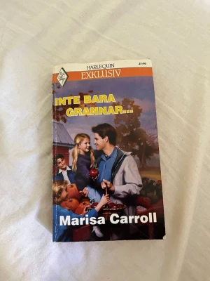 Inte bara grannar av Marisa Carroll - En romantisk pocketbok från Harlequin Exklusiv, skriven av Marisa Carroll. Omslaget har en färgglad illustration med människor i höstmiljö och tydlig titel i gult. Perfekt för dig som gillar lättläst och känslosam skönlitteratur.