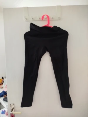 Svarta tighta leggings med scrunch - Säljer ett par svarta leggings med scrunch-detalj bak som framhäver formen. De är tighta och har hög midja, perfekta till både träning och chill. Materialet känns mjukt och stretchigt, Passar dig som gillar en clean och enkel stil. Vet tyvärr inte vart dom kommer ifrån 