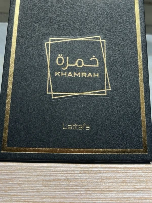 Byte - Khamrah parfym från Lattafa i en elegant svart förpackning med gulddetaljer och stilren design. Förpackningen har arabiska och engelska texter i guld, vilket ger en lyxig känsla. Perfekt för dig som gillar exklusiva dofter.