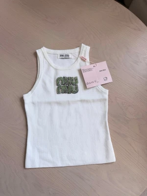 Stickad vit tanktop med strass / glittrig topp" - Sjukt fin vit stickad tanktop med fina strassdetaljer framtill. Helt ny med lappar kvar! Säljer då den tyvärr inte kom till användning. Det är One Size och materialet är stretchigt så den passar de flesta. Priset kan diskuteras 