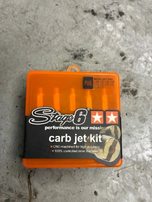 Stage6 carb jet kit orange - Säljer ett Stage6 carb jet kit i en orange plastask. Kitet innehåller flera munstycken för förgasare, CNC-tillverkade för hög precision och med kontrollerad innerdiameter. Perfekt för dig som vill justera din moped eller scooter.