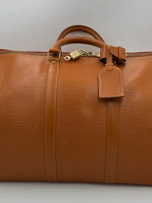 Louis Vuitton Keepall 50  - Tidlös investering. Begagnad lyxväska LOUIS VUITTON KEEPALL 50 i EPI-läder. Mångsidig och slitstark väska, erbjuder ikonisk stil och premiumkvalitet. Vacker honungsfärg. Insidan har några fläckar men är mycket rymlig.