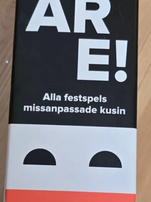 Sällskapsspel Rackare,  partyspel - Rackare är ett sällskapsspel med svart, vit och orange kartong. Spelet beskrivs som alla festspels missanpassade kusin och passar perfekt för roliga kvällar med vänner. Lådan har en lekfull design med enkla former och tydlig text.