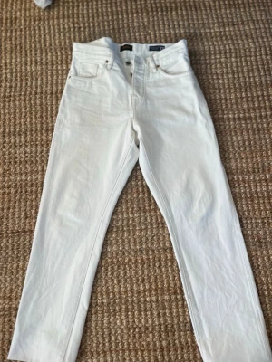 Vita raka jeans från Carlslund - Snygga vita jeans från Carlslund med rak passform och hög midja. Klassisk femficksmodell med knappgylf och bälteshällor. Perfekta till en clean och fräsch look året runt. Står att dom är 30 men skulle nog säga att de är mer som 32