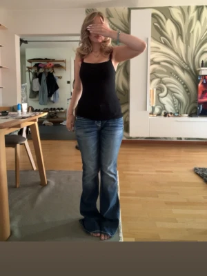 Low waist bootcut miss me jeans  - Säljer ett par blå bootcut jeans med snygga broderade detaljer på bakfickorna. Jeansen har en klassisk femficksmodell och sitter normalt i midjan. Perfekta för dig som gillar en avslappnad men ändå trendig look.