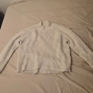 Vit kabelstickad tröja med polokrage - Säljer en vit kabelstickad tröja med polokrage från märket ADPT. Storleken är xs men den är oversized. 