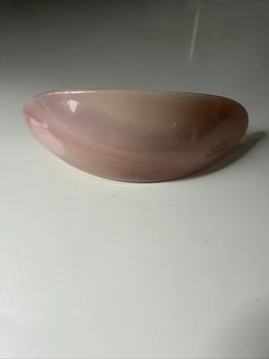 Ljusrosa hårklämma i plast - Säljer en stilren ljusrosa hårklämma med mjuka former. Klämman har en blank finish och är tillverkad i plast. Perfekt accessoar för att snabbt fixa frisyren och ge en söt touch till din look.