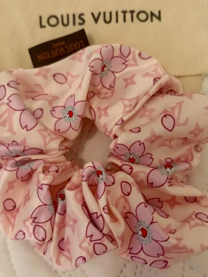 🍒🌸Helt ny scrunchie i silke, cherry blossom-mönster - Superfin, helt ny och oanvänd scrunchie i ljusrosa siden med ikoniskt monogram och blommigt mönster i rosa och lila toner. Perfekt accessoar för att piffa upp håret eller handleden med en lyxig touch och design à la LV x Murakami-serien.