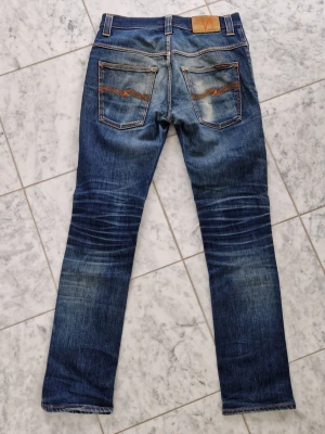 Nudie Jeans Thin Finn fades - Ett par riktigt feta Nudie Jeans i modellen Thin Finn! Bland de fetaste jeansen jag har sett. Storlek W31 L32 Mått: Midja: 36cm Benlängd: 100cm Innerbenslängd: 72cm Benöppning: 15cm