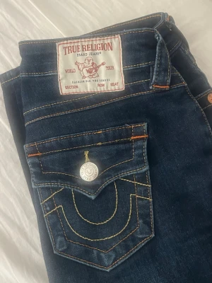 True religion jeans-BECCA - Säljer mina true religion jeans i modellen BECCA! säljer då jag inte riktigt använder dom. Som ni ser är det lite slitet längst ner då dom är rätt så långa, men det är inget som man tänker på eller märker när man har på sig dom! Dom är inte heller uppsydda något utan det är den originella längden! Dom är i storlek W25 och passar mig som är 170, dock lite lite långa! Det enda man märker när det kommer till användning är det slita längst ner, annars ser dom ut som nya!!🩷
