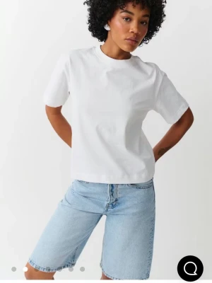 Vit boxy t-shirt i bomull - Säljer en klassisk vit t-shirt med boxy passform och rund hals. T-shirten är gjord i mjuk bomull och har korta ärmar. Perfekt för dig som gillar en enkel och clean look.