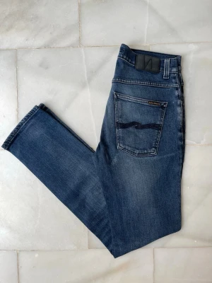 Blå jeans från Nudie Jeans - Säljer ett par feta blå Nudie Jeans i mycket bra skick. Modellen är Grim Tim 😊——————————————————————————                                  📐| Storlek: 31-32                                                   👖| Märke: Nudie Jeans                                         🔎 | Skick: Mycket Bra                                            💵 | Ny Pris: 1599kr                                                 ✍🏻 | Skriv om du har några frågor