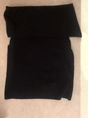 Svart offshoulder tubtopp - Trendig svart offshoulder tubtopp med bred kant upptill. Perfekt att matcha med jeans eller kjol. Toppens material känns mjukt och stretchigt. Har bara inte kommit till användning. 