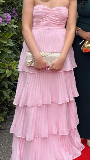 Ljusrosa axelbandslös balklänning - Säljer nu min älskade balklänning!! Den är endast använd en gång och är så gott som ny!! Köpte för 1200kr ♥️har klippt bort lappen men gissar att den är storlek S