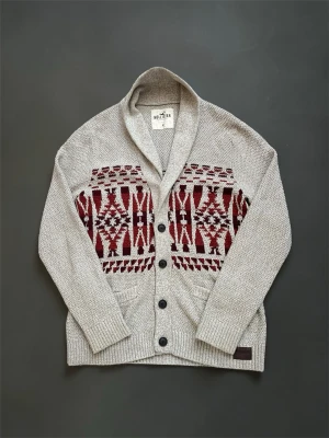 Beige Hollister kofta i storlek M - Schysst beige Hollister kofta med rött mönster och knappar Hör av er vid frågor!