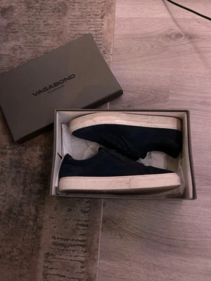 Mörkblå Vagabond sneakers i mocka - Snygga mörkblå sneakers från Vagabond i mocka med klassisk låg profil och vita sulor. Skorna har mörkblå skosnören och en stilren design som passar till det mesta. Perfekta för dig som gillar en clean och enkel look. Änvänt ungefär 3 gånger