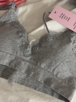 Grå spets-bh från H&M - Snygg grå bh från H&M med spetsdetaljer och justerbara axelband. Bh:n är sömlös och har uttagbara inlägg för extra komfort. Tillverkad i mjukt material som känns skönt mot huden. Helt ny med prislapp!! 200kr ny har jag för mig, borde egentligen kunna använda samma pris då med tanke på ej använd och lapp kvar, varför ej använd vet inte faktiskt! Men säljer endast för 140kr😍