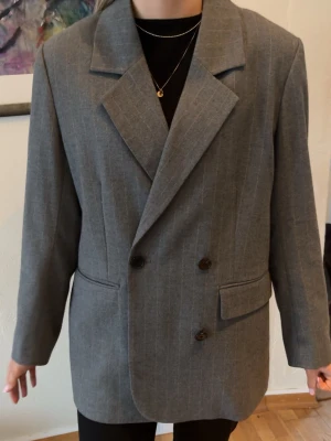 Grå kavaj från Second Female - Hej!🌸 Jag säljer en stilren grå kavaj från Second Female med diskreta kritstreck, breda slag och dubbelknäppning framtill. Ett klassiskt plagg som passar till många olika outfits. Kavajen är sparsamt använd och i mycket bra skick!      Nypris 1500 kr.