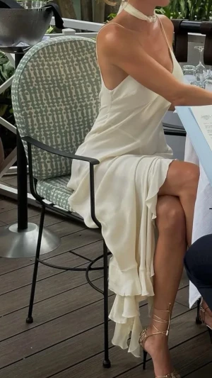 Victoria Beckham Vit viskos klänning med volang, M - Säljer en elegant vit långklänning med omlottdesign och volangdetaljer längs nederkanten. Klänningen har smala axelband och en v-ringad urringning som ger en stilren och feminin look. Perfekt för sommarens alla tillfällen! Victoria Beckham xMango