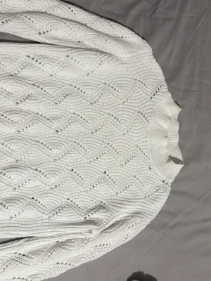 Vit stickad tröja från Stories - Säljer en vit stickad tröja från Stories i storlek S (36-38). Tröjan har ett snyggt strukturmönster och ribbad hög hals. Perfekt för de som gillar klassisk och stilren design. 