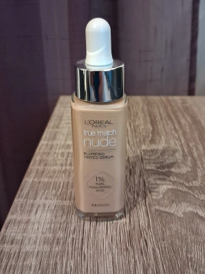 L'Oréal True Match Nude Foundation - Ljusbeige foundation-serum från L'Oréal Paris True Match Nude med pipettapplikator. Innehåller 1% hyaluronsyra för återfuktning och ger en naturlig, strålande finish. Passar känslig hud och är lätt att applicera tack vare den flytande formulan.