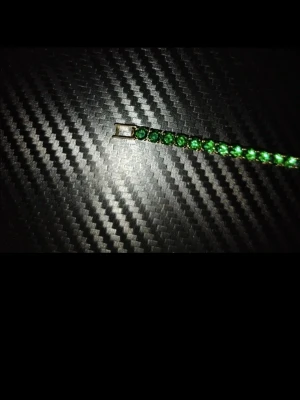 Armband  - Snyggt tennisarmband med runda, gröna Diamonds i rad på en metallkedja. Armbandet har en klassisk och stilren design som verkligen sticker ut med sina klara gröna stenar. Perfekt för dig som vill ha något färgstarkt och elegant på handleden. Den är 18cm lång.