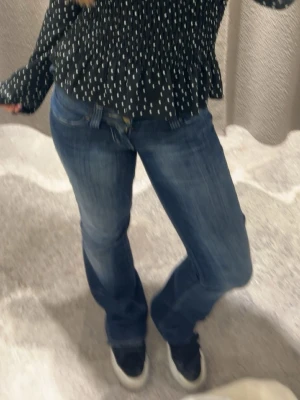 Mörkblå bootcut jeans - Snygga mörkblå bootcut jeans med klassisk femficksdesign och lätt slitna detaljer. Jeansen har normal midja och är tillverkade i ett stretchigt denimtyg för skön passform. Perfekta för en avslappnad och trendig look.