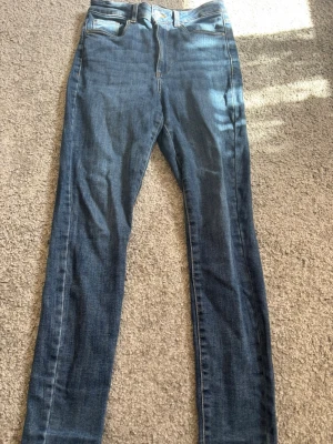 Blå skinny jeans från Vero Moda - Säljer ett par klassiska blå skinny jeans från Vero Moda. Jeansen har fem fickor, normal midja och är tillverkade i stretchigt denimtyg för en bekväm passform. Perfekta till alla typer av outfits och superenkla att styla.