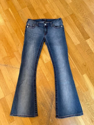  True Religion jeans  - Säljer ett par blå bootcut jeans med låg midja från true religion. Jeansen är aldrig använda då de är för stora för mig (endast testade) jeansen är köpta för 1400 kr! 