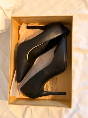 Svarta klassiska pumps från Nelly - Säljer ett par stilrena svarta pumps med spetsig tå och hög klack. Köpte dem på Vinted men var för små för mig, säljer dem i samma skick som jag fick dem! 🩷