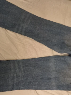 Ljusblå raka jeans - Säljer ett par ljusblå jeans bootcut. Har en liten fläck och är lite sönder