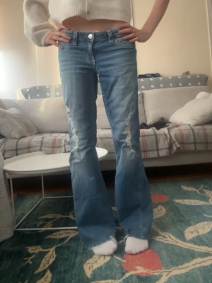 Blå Ginatricot utsvängda jeans med slitningar str M - Säljer dessa jättesnygga bootcut jeansen från Gina tricot 14+ i storlek M. Jag har själv klippt av lite  på längden pågrund av att de var för långa, jag är 162cm men de är lite för långa fortfarande. Skriv gärna för mer information😋💘 