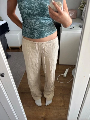 Beiga linnebyxor - XS men passar mig som S. Går att justera i midjan väldigt flexibel. Är dessutom 164 cm och passar mig i längden. Säljer ett par beiga linnebyxor med avslappnad passform och resår i midjan samt dragsko. Byxorna har raka ben och är tillverkade i ett luftigt linnematerial, perfekta för en chill och stilren look.
