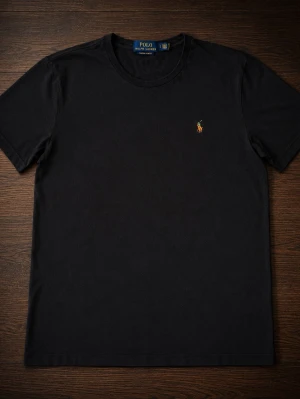 Svart t-shirt från Polo Ralph Lauren - Klassisk svart t-shirt från Polo Ralph Lauren med rund halsringning och liten broderad logga på bröstet. T-shirten är enkel och stilren, perfekt till jeans eller shorts. Tillverkad i mjuk bomull för skön känsla hela dagen.