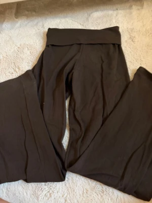 Bruna pricilla Brandy Melville byxor - Mörkbruna mjukisbyxor från Brandy Melville med bred linning och utsvängda ben. Tillverkade i mjukt och stretchigt material som känns skönt mot huden. Perfekta för en avslappnad och chill stil.